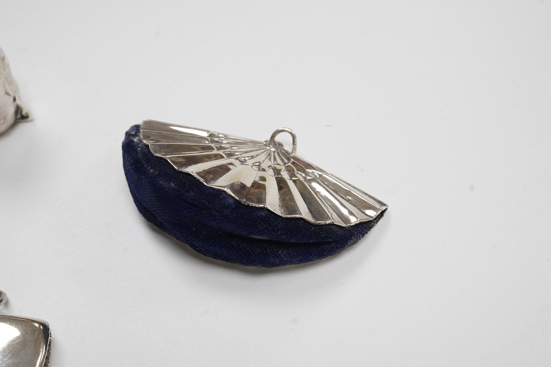 A George V silver mounted fan pin cushion, Henry Matthews, Birmingham, 1912, width 62mm, together with an Edwardian silver vesta case and a white metal pig vesta case.